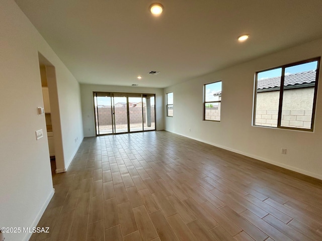 unfurnished room featuring baseboards, dark wood-style floors, visible vents, and recessed lighting