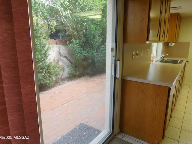 doorway with sink and light tile patterned floors