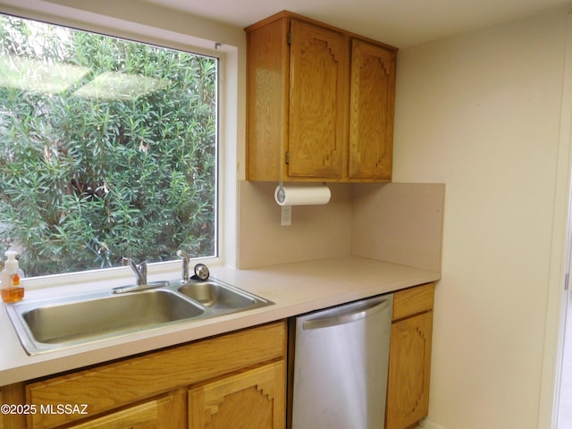 kitchen featuring a wealth of natural light, dishwasher, light countertops, and a sink