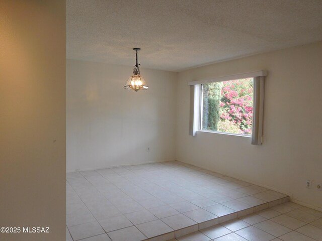 spare room with light tile patterned floors and a textured ceiling