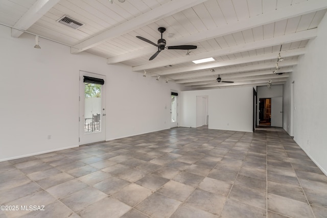 empty room with ceiling fan, beamed ceiling, and a skylight