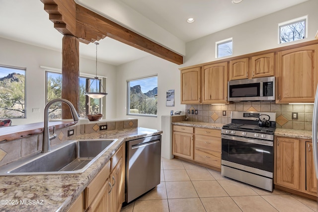 kitchen featuring light tile patterned flooring, sink, tasteful backsplash, appliances with stainless steel finishes, and pendant lighting