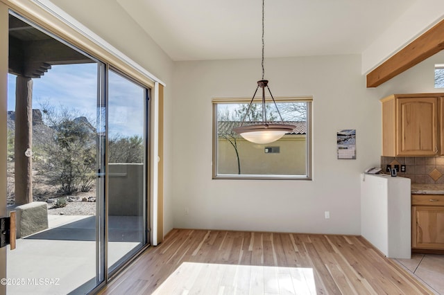 unfurnished dining area featuring a wealth of natural light and light wood-type flooring