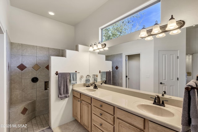 bathroom with tile patterned flooring, vanity, and a tile shower