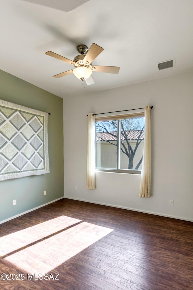 empty room featuring dark hardwood / wood-style flooring and ceiling fan