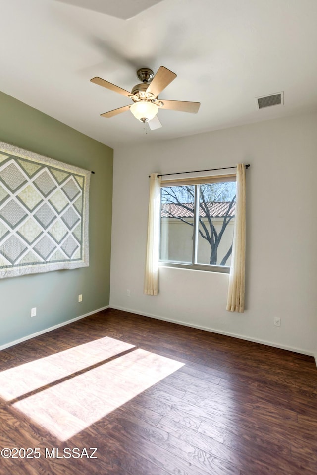 spare room with ceiling fan and dark hardwood / wood-style flooring