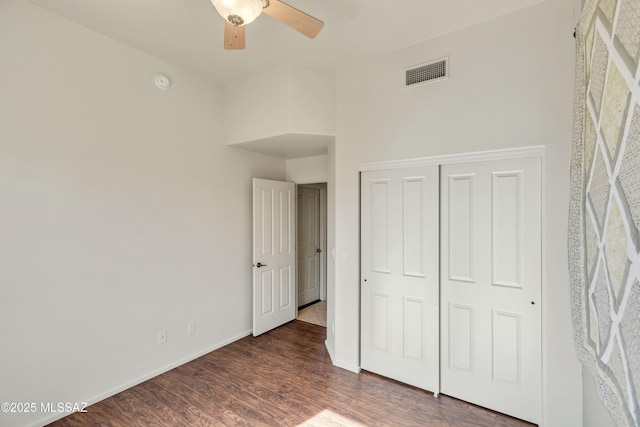 unfurnished bedroom featuring dark hardwood / wood-style flooring, a closet, and ceiling fan