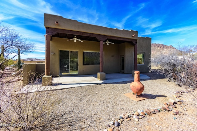 back of property featuring a mountain view, a patio area, and ceiling fan