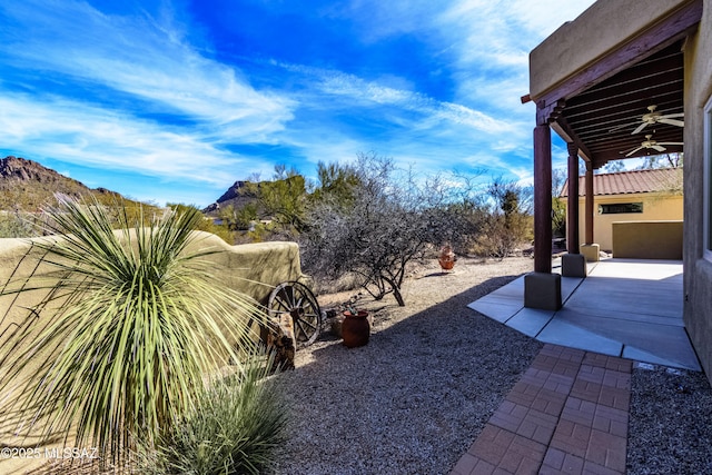 view of yard featuring ceiling fan and a patio