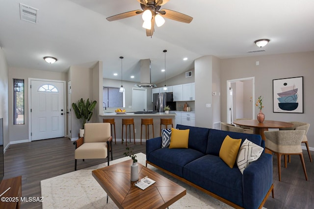 living room with ceiling fan, dark hardwood / wood-style flooring, and vaulted ceiling