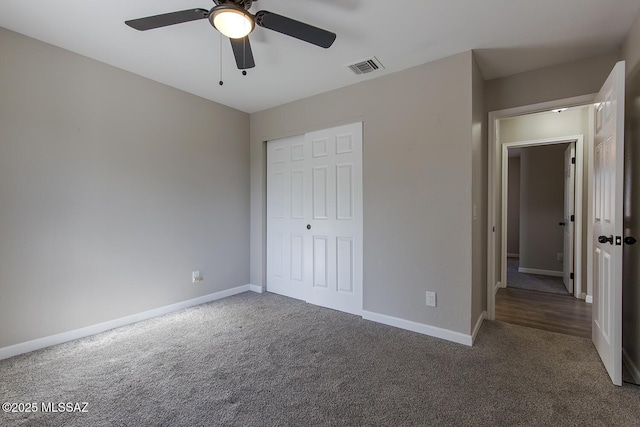 unfurnished bedroom featuring dark carpet, a closet, and ceiling fan