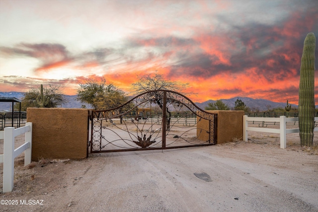 gate at dusk featuring a mountain view