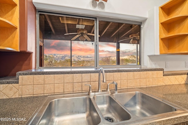 kitchen featuring tasteful backsplash, ceiling fan, and sink