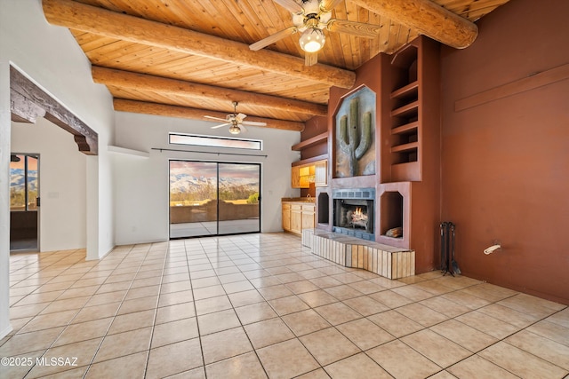 unfurnished living room with beamed ceiling, light tile patterned flooring, ceiling fan, and wood ceiling