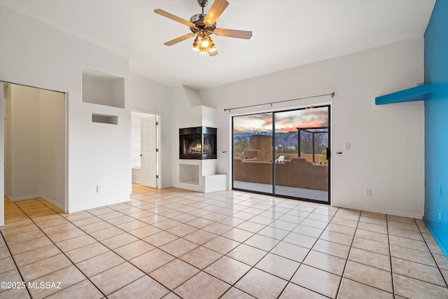 unfurnished living room featuring ceiling fan, a multi sided fireplace, and light tile patterned floors