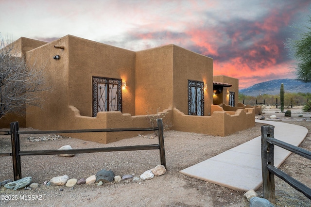 property exterior at dusk featuring a mountain view