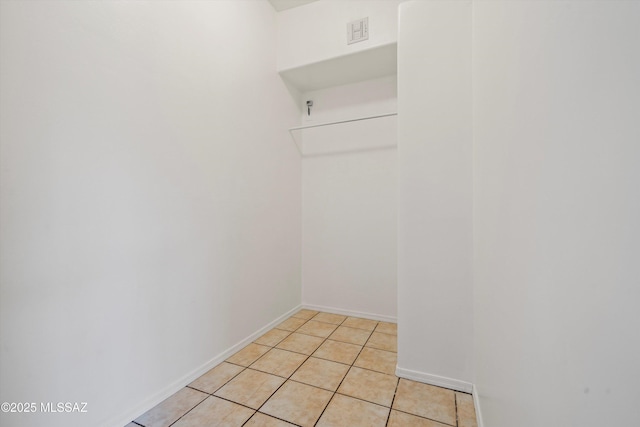 walk in closet with light tile patterned floors