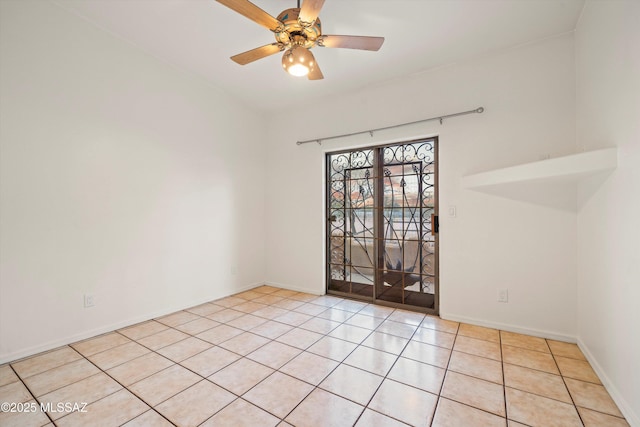 tiled spare room featuring ceiling fan