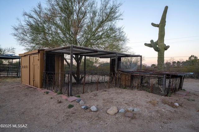 yard at dusk featuring an outdoor structure