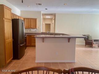 dining area with a ceiling fan, visible vents, baseboards, and light tile patterned floors