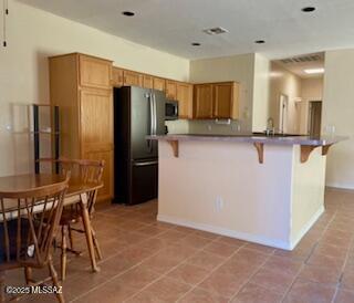 kitchen with light tile patterned floors, stainless steel appliances, recessed lighting, light countertops, and visible vents