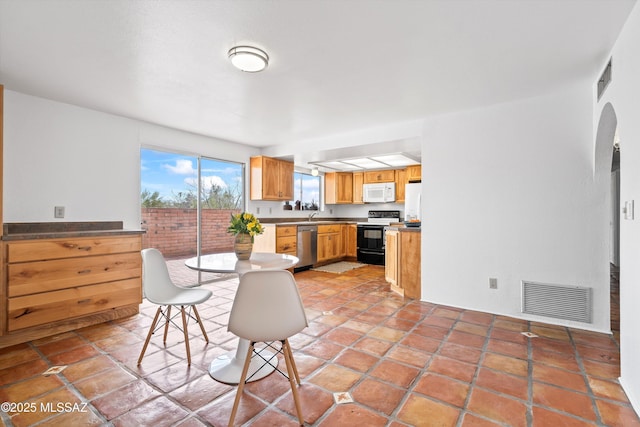 kitchen featuring stainless steel dishwasher, light tile patterned floors, and electric range