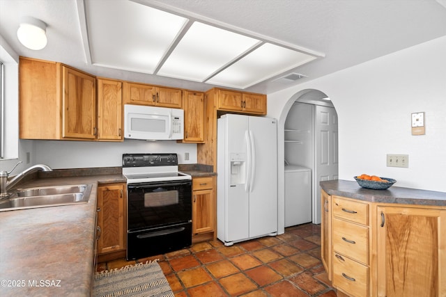 kitchen featuring white appliances, washer / dryer, and sink