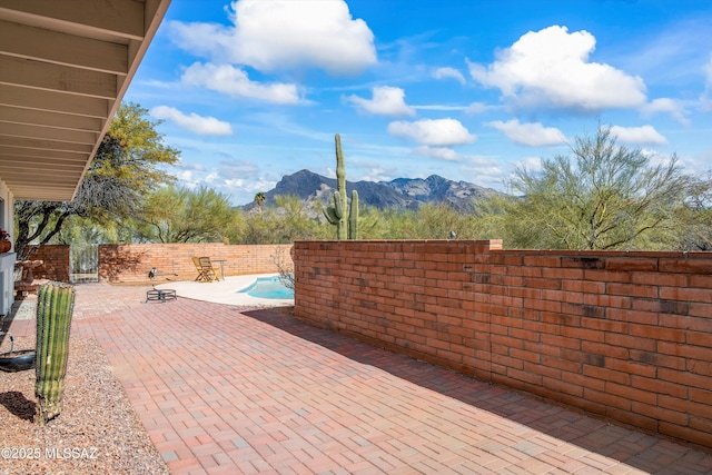 view of patio with a mountain view and a fenced in pool