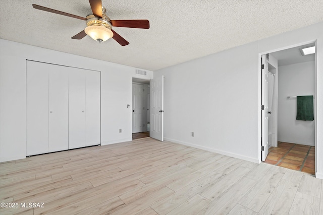 unfurnished bedroom with a closet, ceiling fan, a textured ceiling, and light hardwood / wood-style flooring