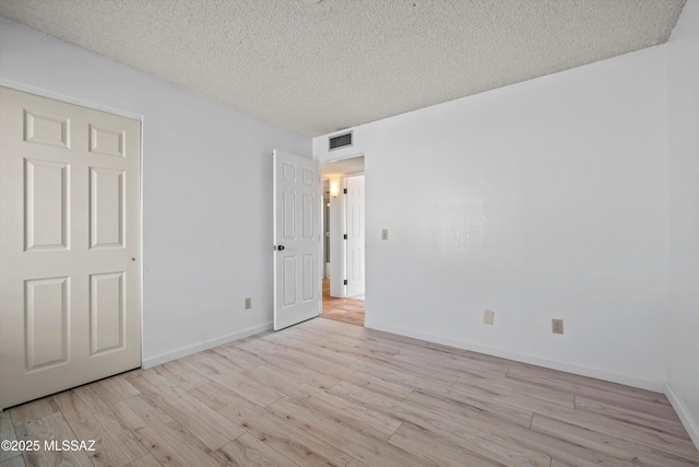 unfurnished bedroom featuring light hardwood / wood-style flooring and a textured ceiling