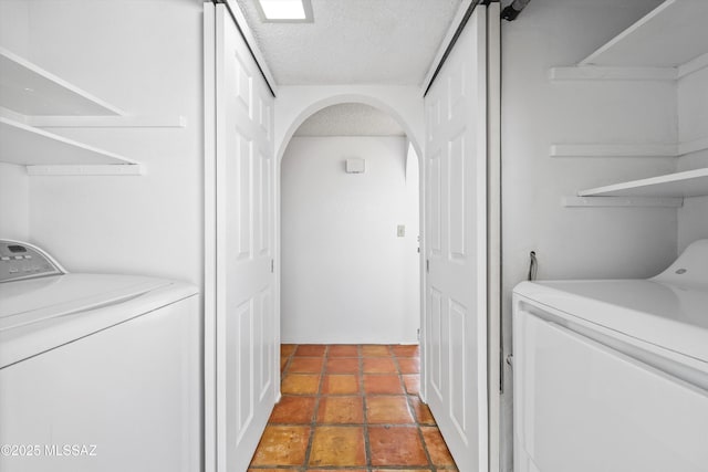 laundry room featuring washing machine and dryer and a textured ceiling