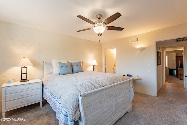 carpeted bedroom featuring ceiling fan and brick wall