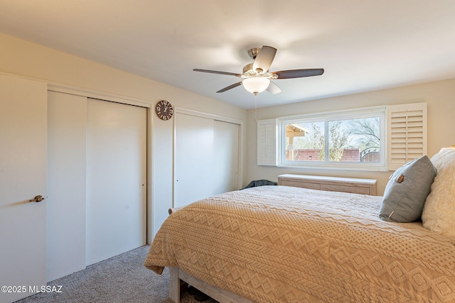 carpeted bedroom with two closets and ceiling fan