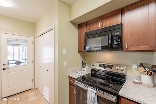 kitchen featuring stainless steel electric stove and light tile patterned floors