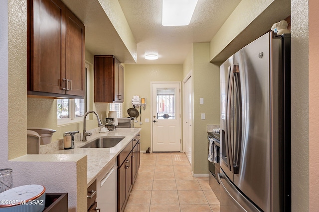 kitchen featuring sink, light tile patterned floors, a healthy amount of sunlight, and appliances with stainless steel finishes