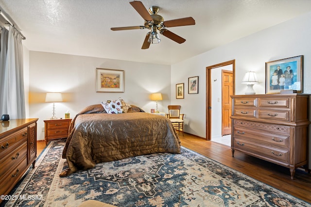 bedroom featuring ceiling fan, baseboards, and wood finished floors