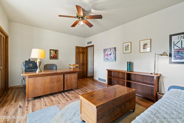 office with a ceiling fan, wood finished floors, visible vents, and baseboards