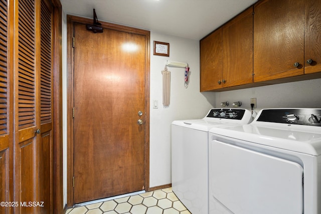 laundry room featuring baseboards, cabinet space, light floors, and washing machine and clothes dryer