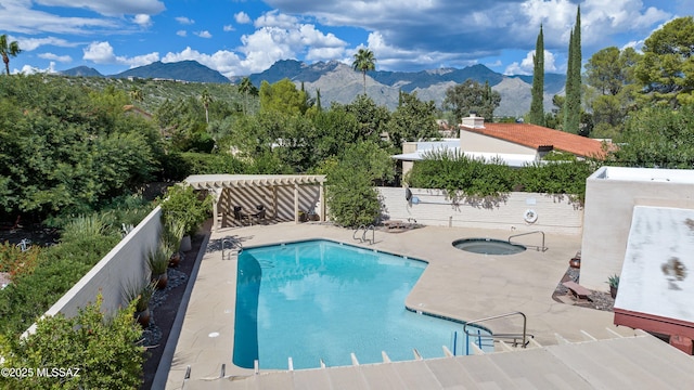 community pool with a pergola, a fenced backyard, a mountain view, a community hot tub, and a patio