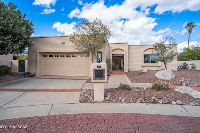 view of front facade with driveway, a garage, and fence