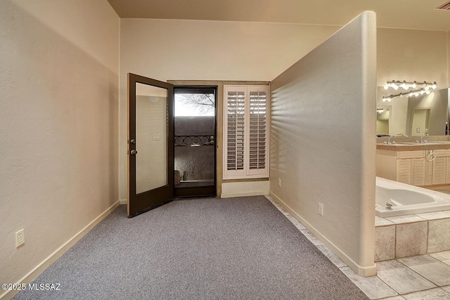 interior space featuring a textured wall, vanity, and baseboards