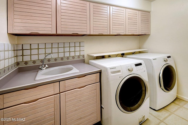 clothes washing area featuring light floors, independent washer and dryer, a sink, and cabinet space