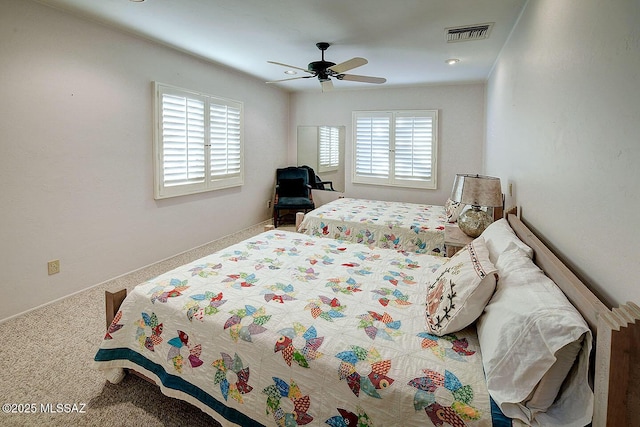 carpeted bedroom featuring a ceiling fan and visible vents