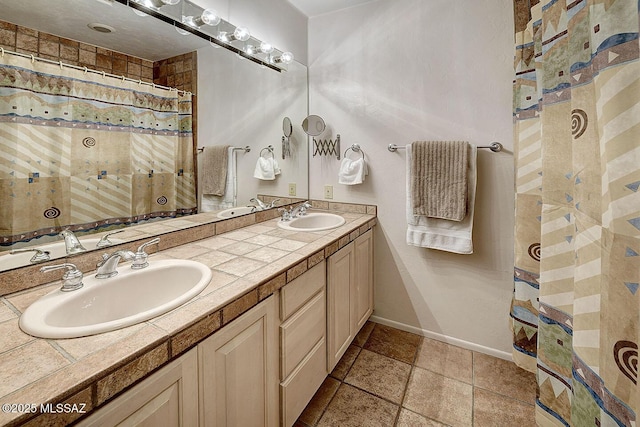 bathroom with double vanity, baseboards, and a sink