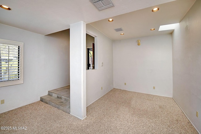 basement with carpet floors, recessed lighting, and visible vents