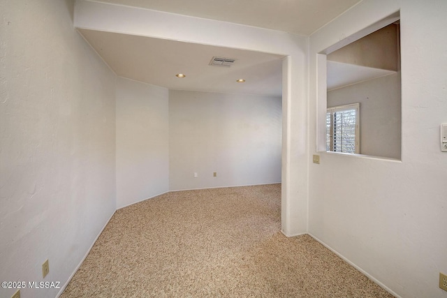 spare room featuring carpet flooring and visible vents