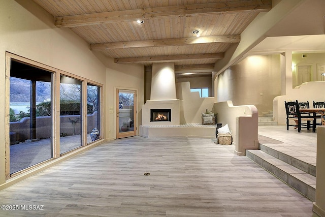 interior space featuring a large fireplace, wood ceiling, beam ceiling, and wood finished floors