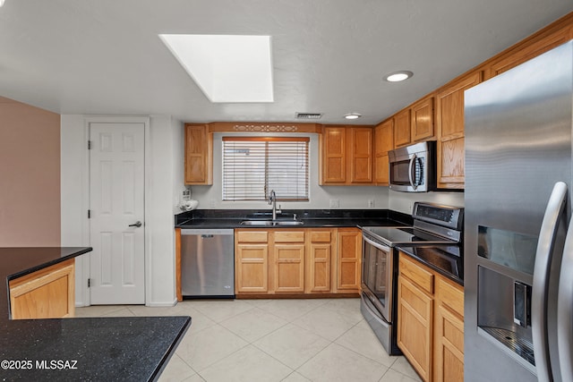 kitchen with sink, light tile patterned floors, and stainless steel appliances