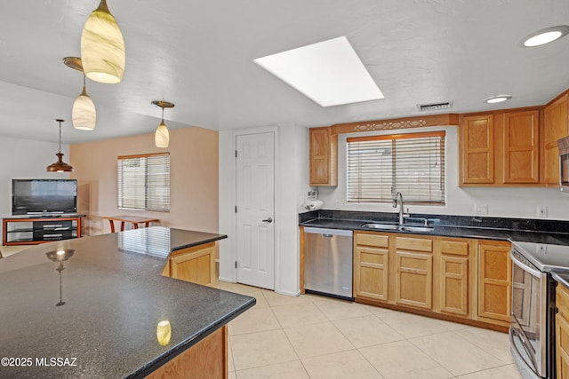 kitchen with light tile patterned flooring, pendant lighting, a skylight, sink, and stainless steel appliances