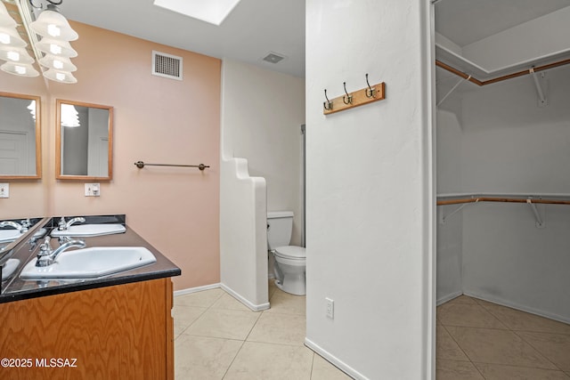 bathroom featuring vanity, toilet, and tile patterned flooring